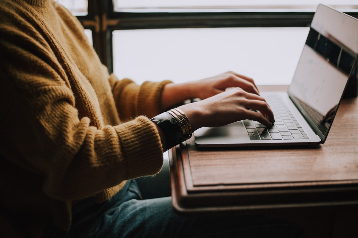 Person typing on a laptop in a focused home workspace