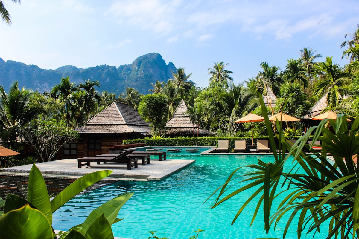 Swimming pool with sun loungers at a social venue during a warm afternoon