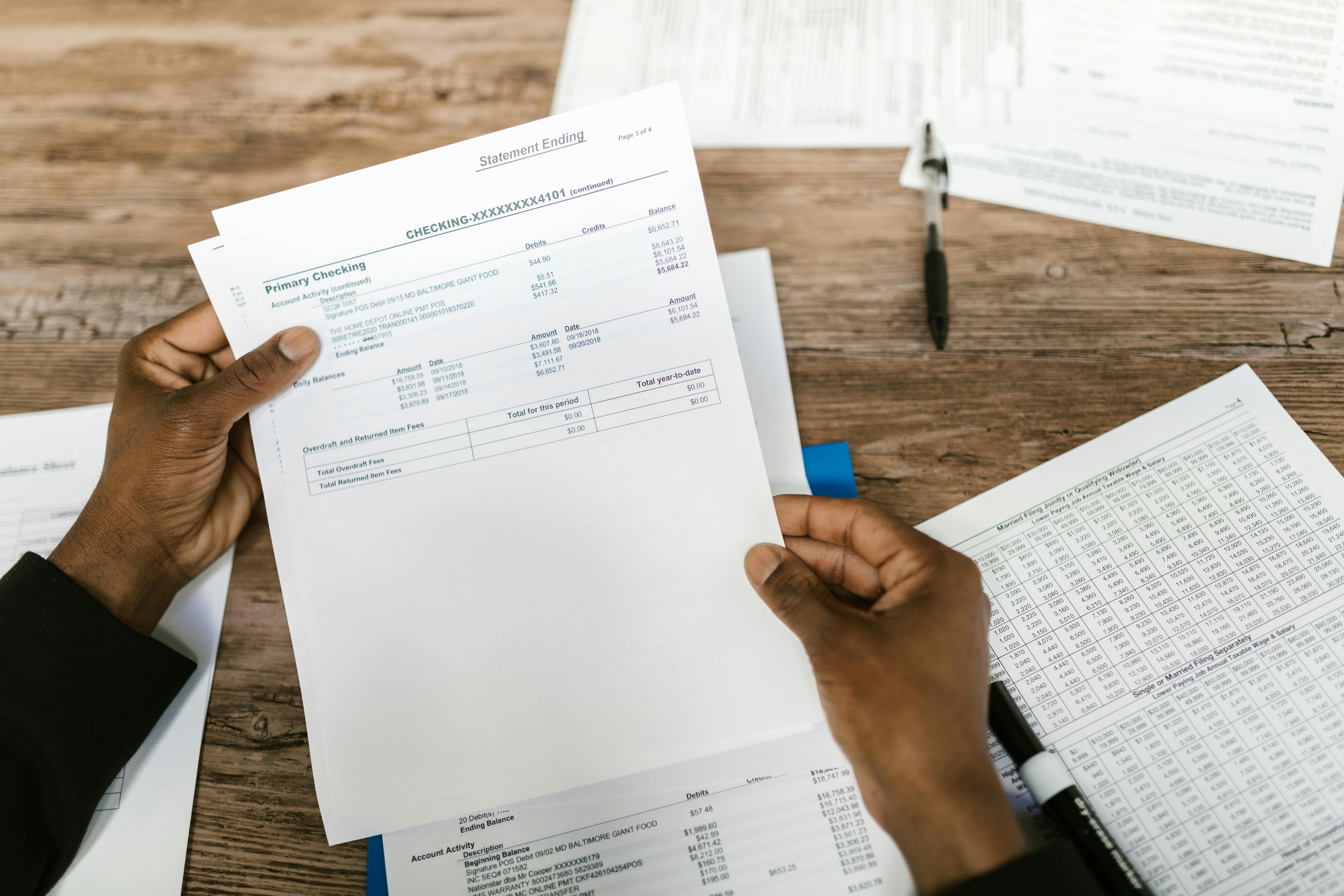 Hands holding financial papers for review