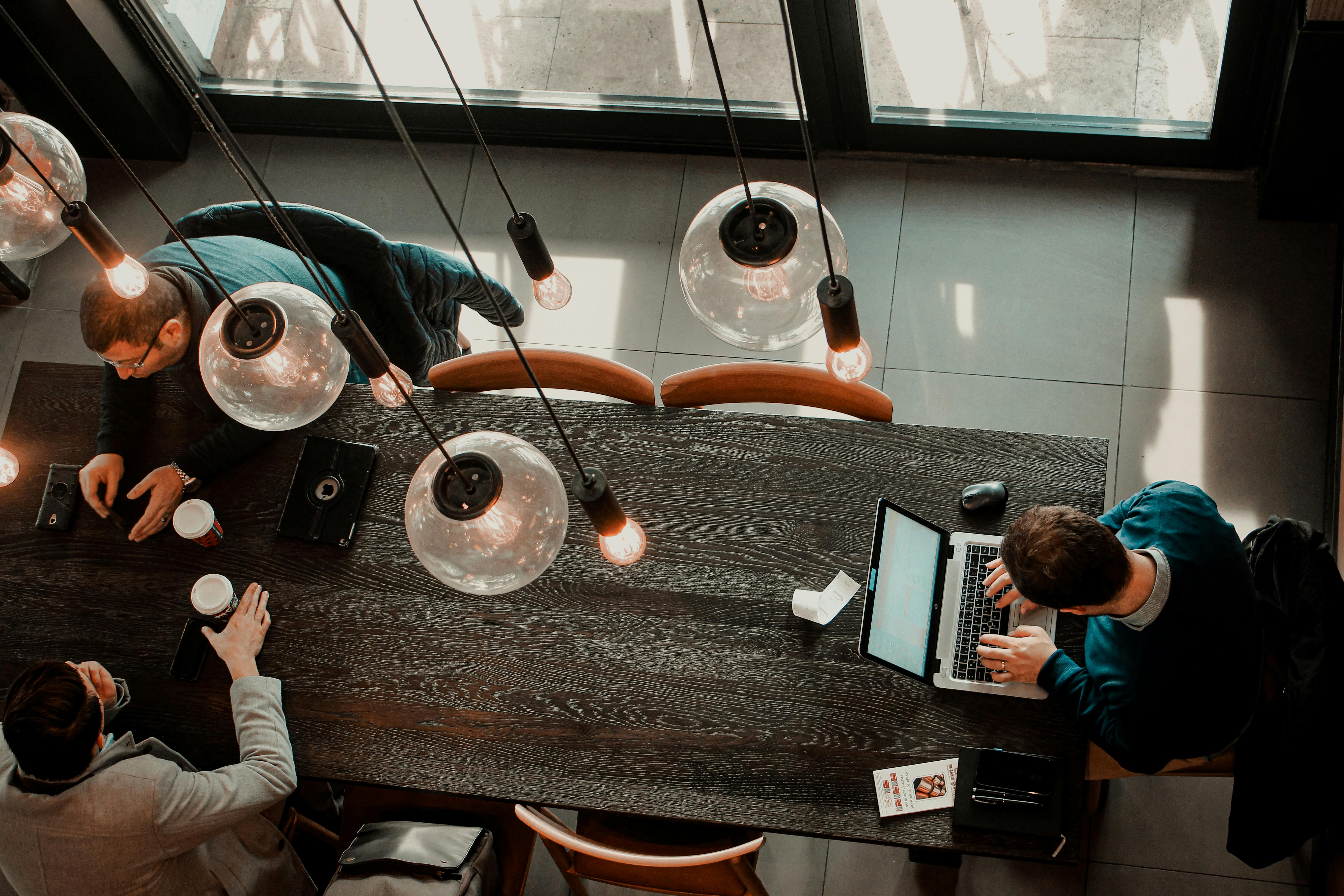 Overhead view of people working with laptops and coffee