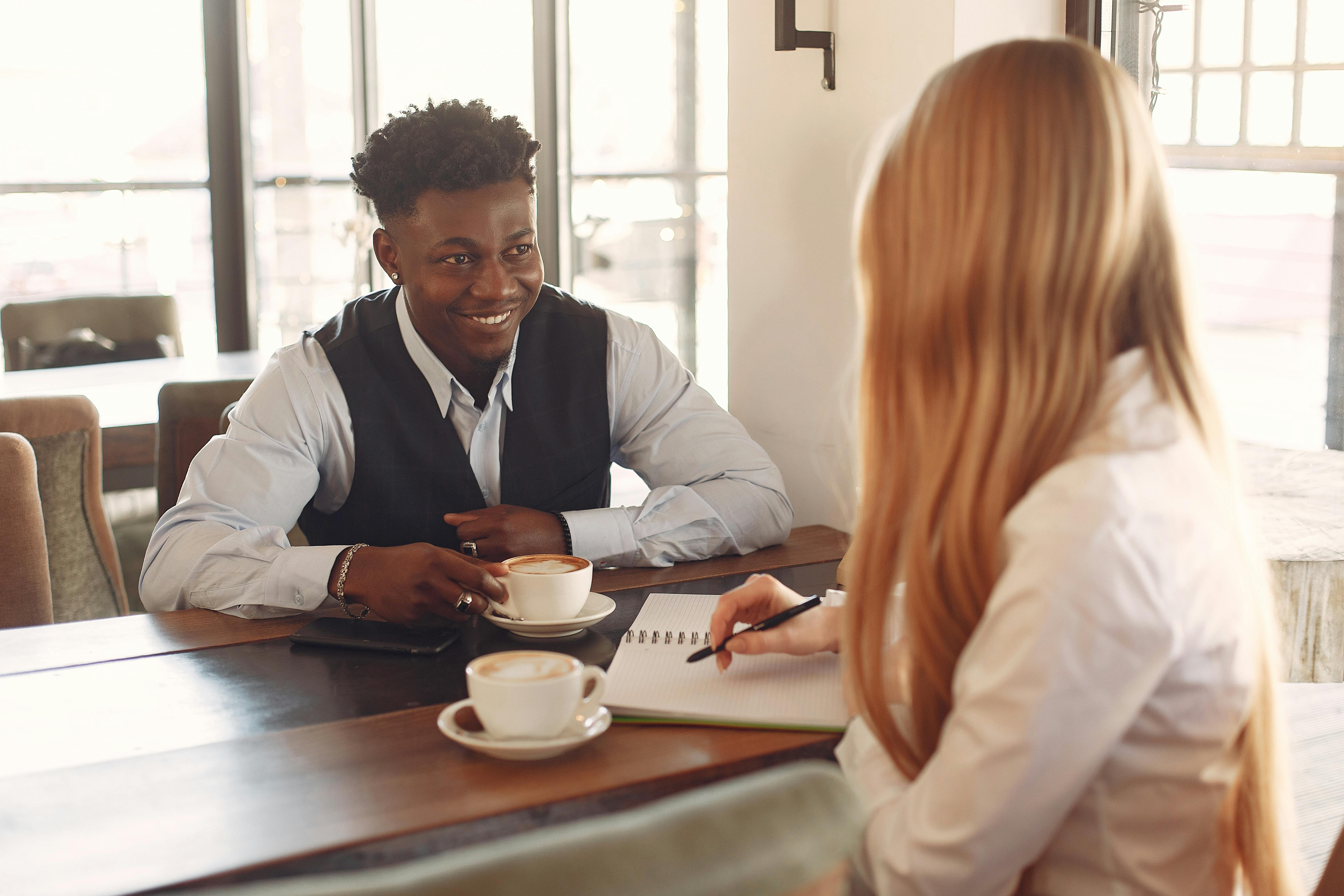 Two people talking over coffee in a cafe